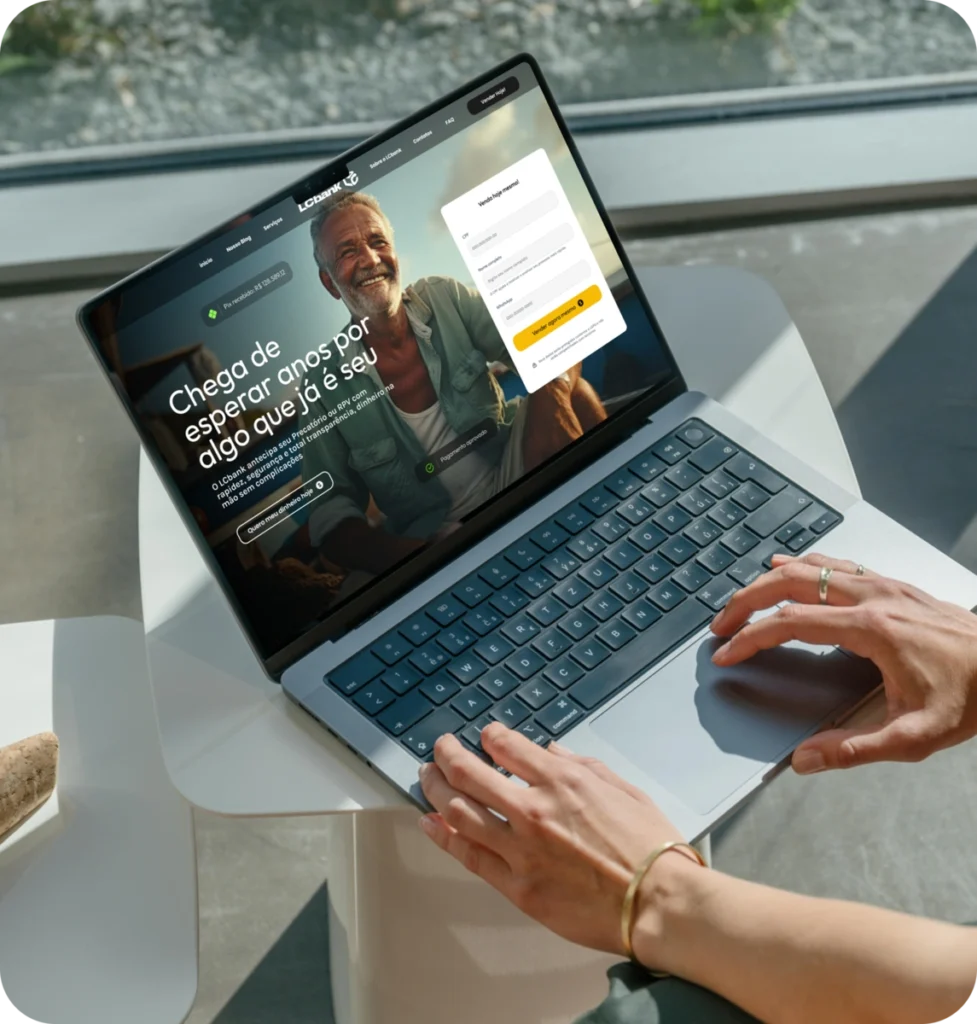 Notebook aberto com tela exibindo homem sorridente e texto "Menos Burocracia Mais Dinheiro