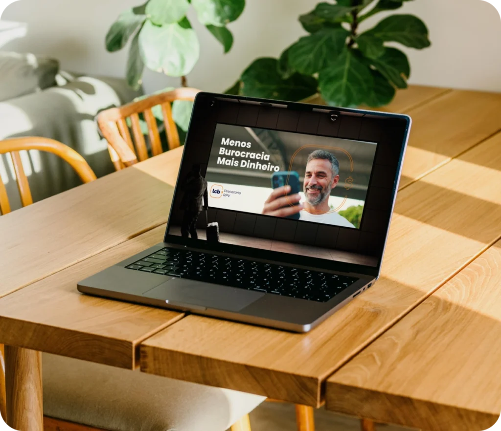 Laptop com tela exibindo "Menos Burocracia Mais Dinheiro" e logo LCbank